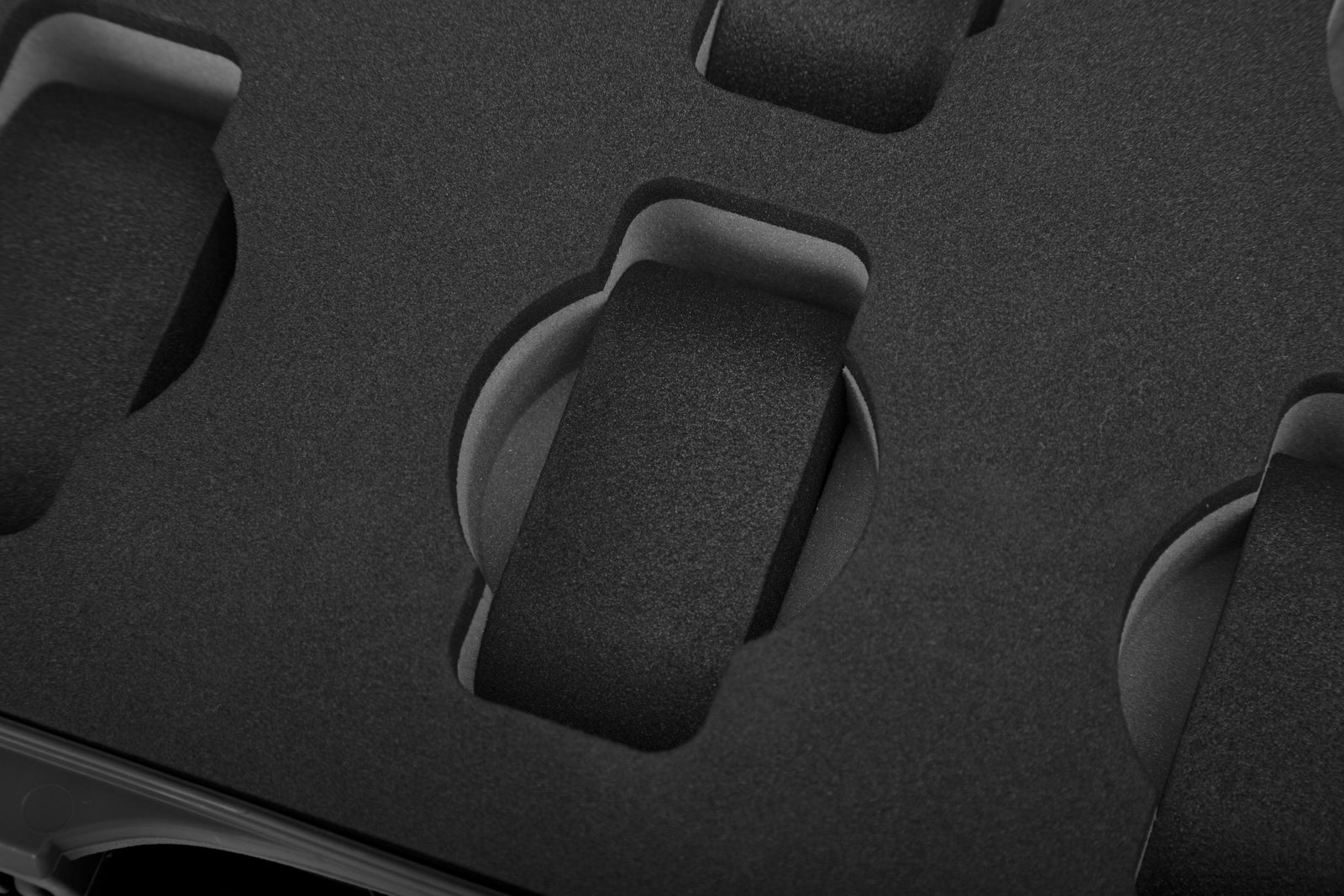 Close-up of a textured black surface with circular cutouts