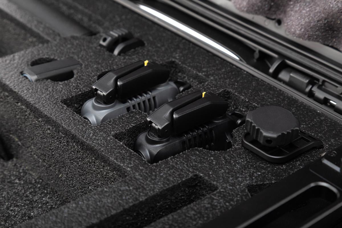 Black foam-lined interior of a case with various components.
