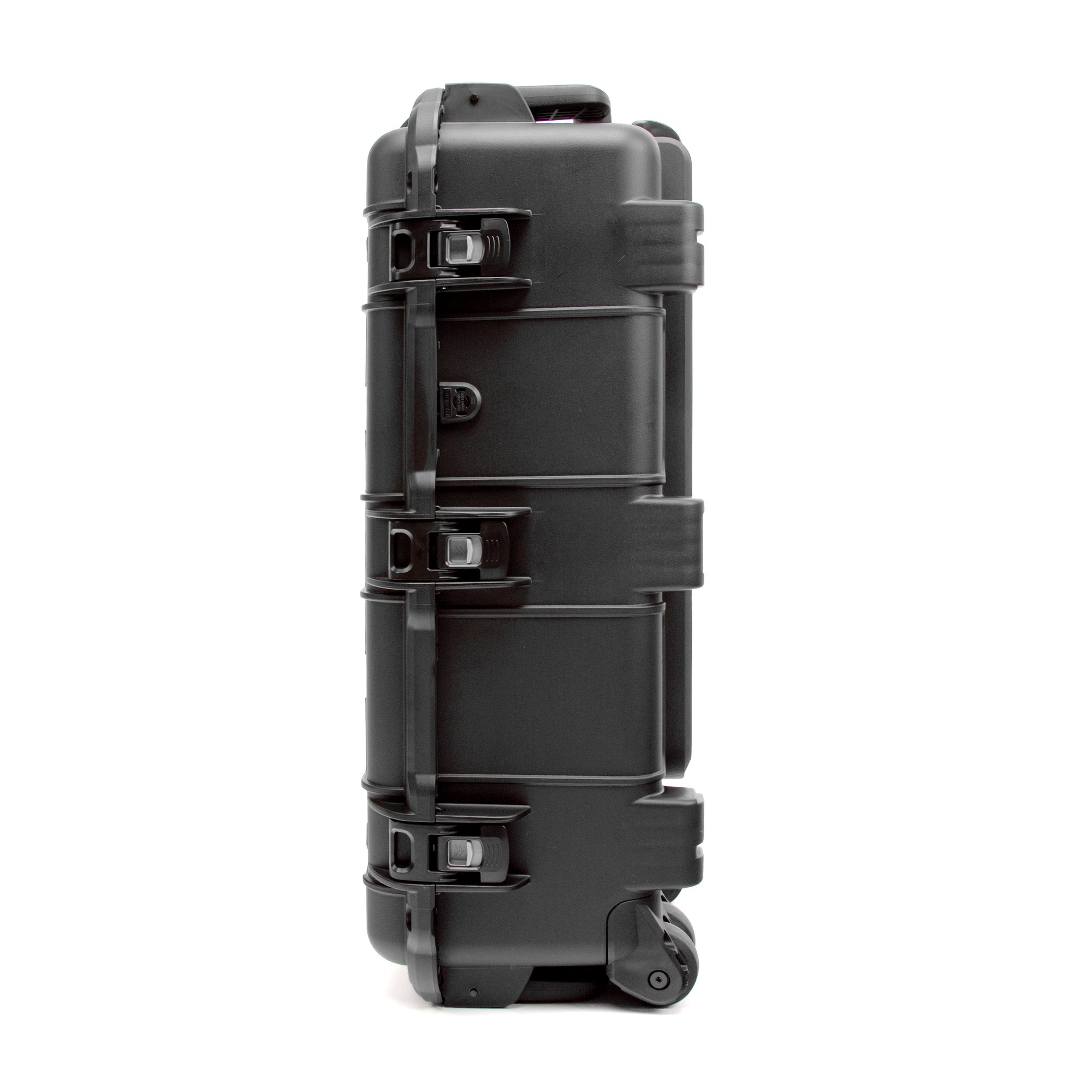A black hard-shell rolling equipment case with multiple locking latches and a telescoping handle, shown from a side profile view on a white background. A black hard-shell rolling equipment case with multiple locking latches and a telescoping handle, shown from a side profile view on a white background.