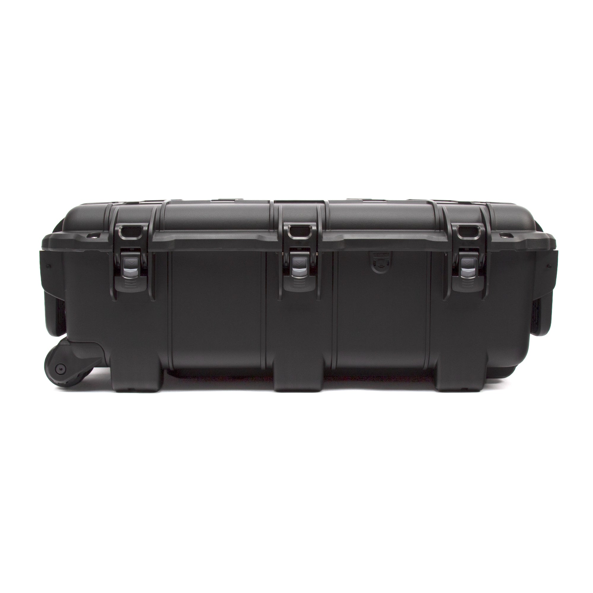 A heavy-duty black hard case with a rolling wheel on the left side and three heavy-duty latches on top, shown from a side profile view against a plain white background. A heavy-duty black hard case with a rolling wheel on the left side and three heavy-duty latches on top, shown from a side profile view against a plain white background.