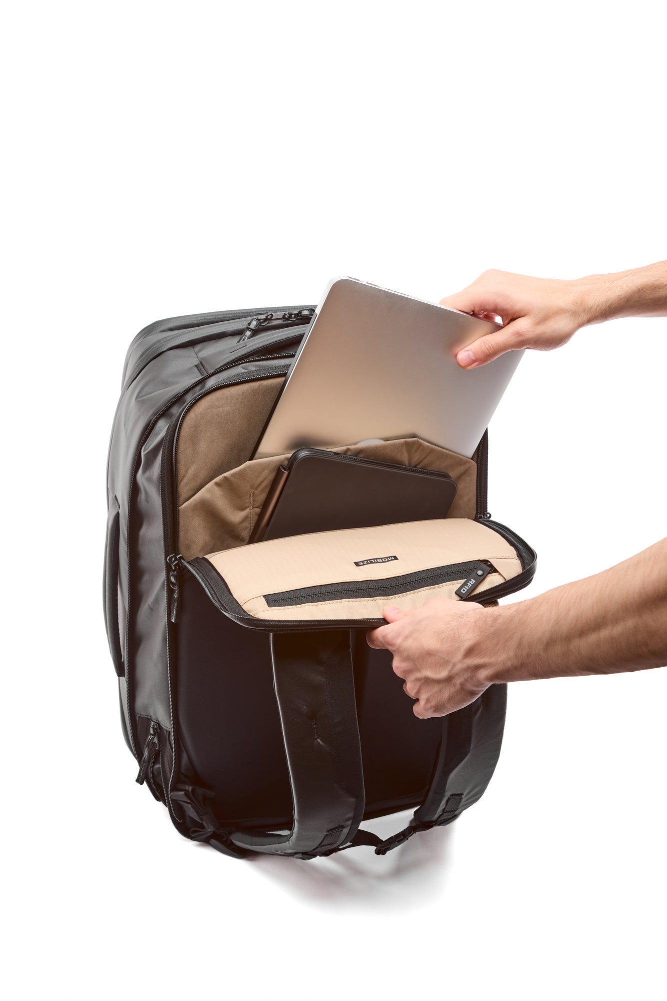 Person placing a laptop into a backpack on a white background Person placing a laptop into a backpack on a white background