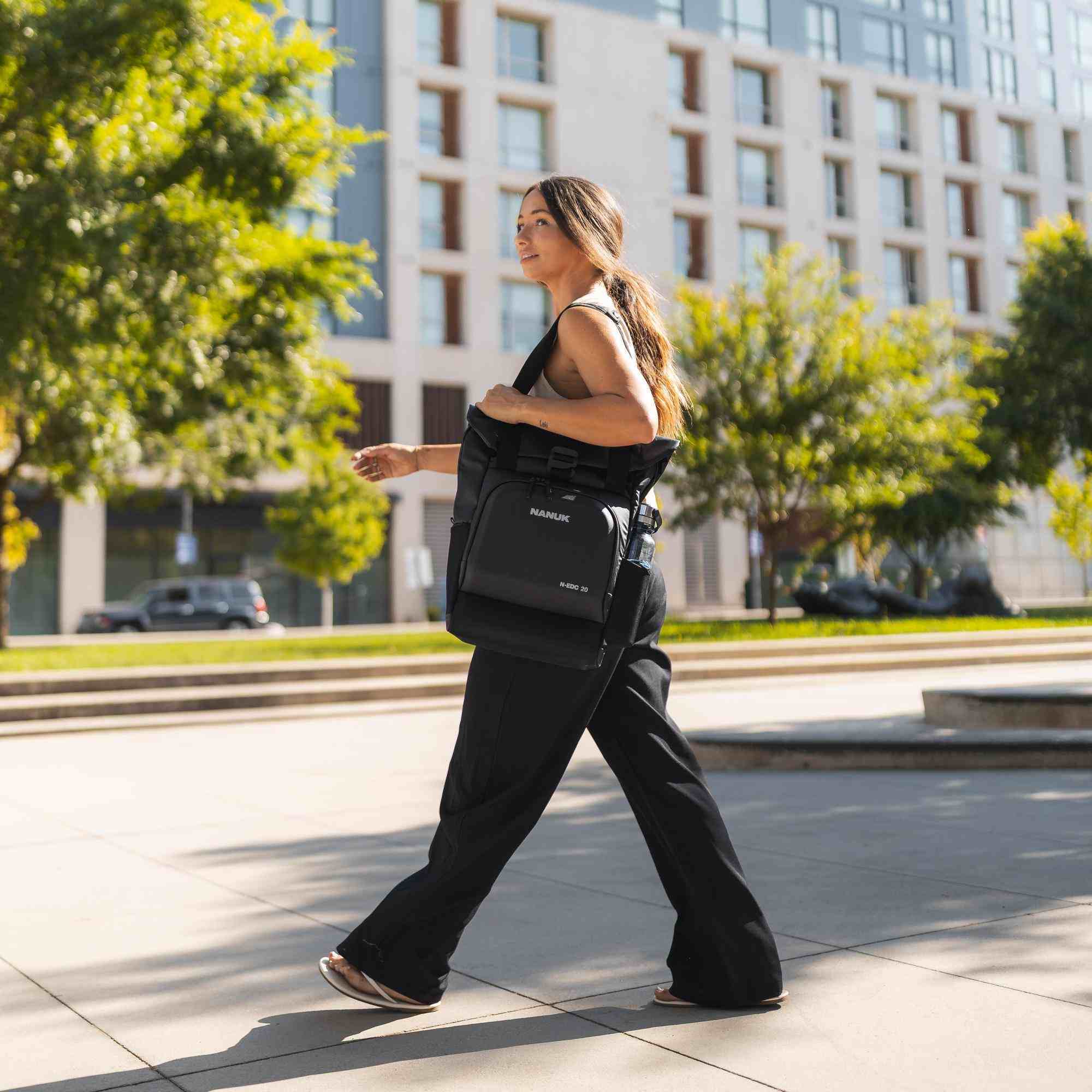 Woman walking outdoors with a black bag in an urban setting Woman walking outdoors with a black bag in an urban setting