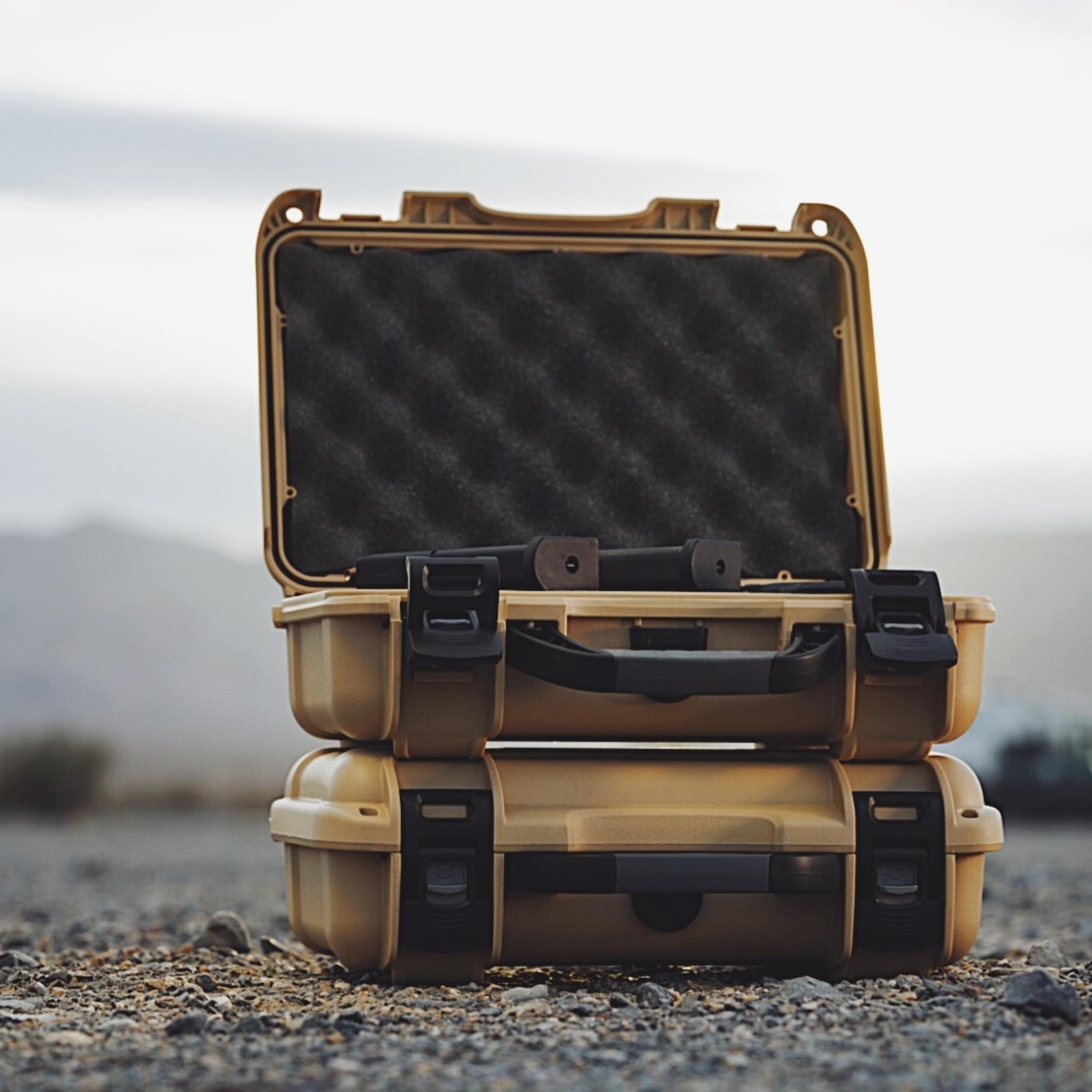 Open beige hard-shell case with black interior on a desert background Open beige hard-shell case with black interior on a desert background