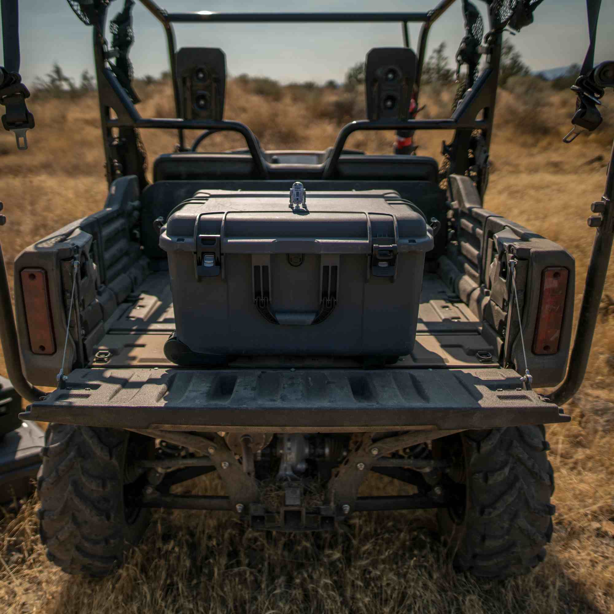 Gray NANUK storage case on the back of a four-wheeler in a field Gray NANUK storage case on the back of a four-wheeler in a field