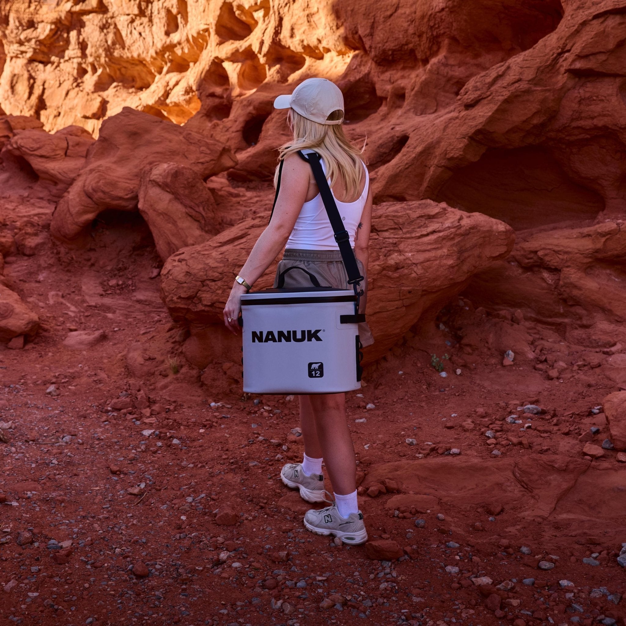 Person holding a Nanuk cooler in a desert landscape