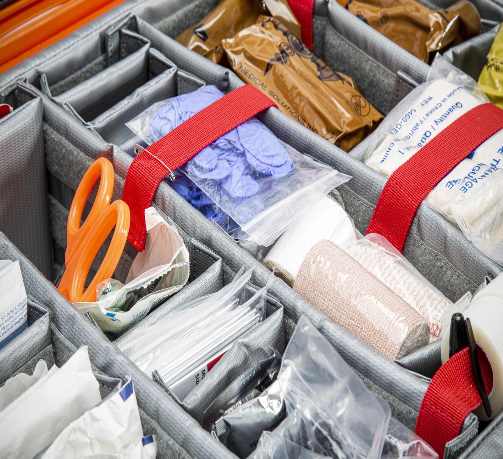 Organized compartments with supplies including scissors, bandages, and other medical items.
