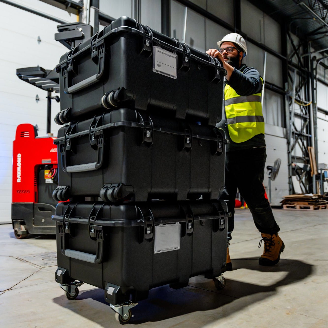 Three Nanuk 976 stacked up and rolled by a construction worker in a warehouse Three Nanuk 976 stacked up and rolled by a construction worker in a warehouse