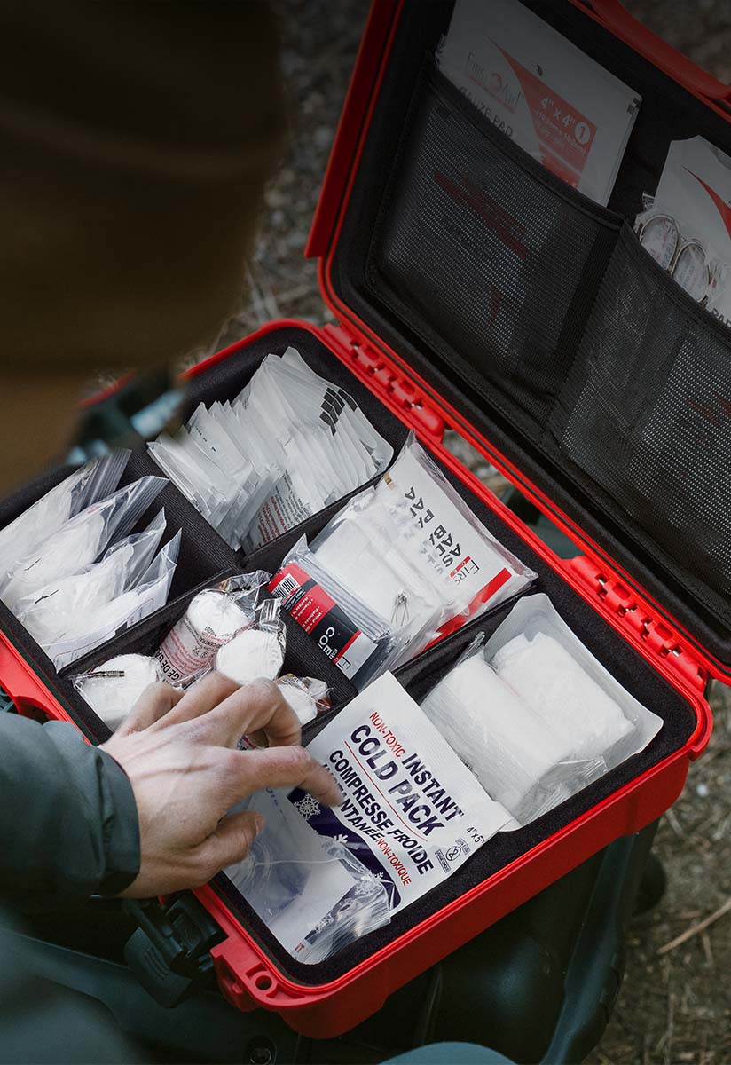 A hiker looking into a filled up First Aid Kit by NANUK Case