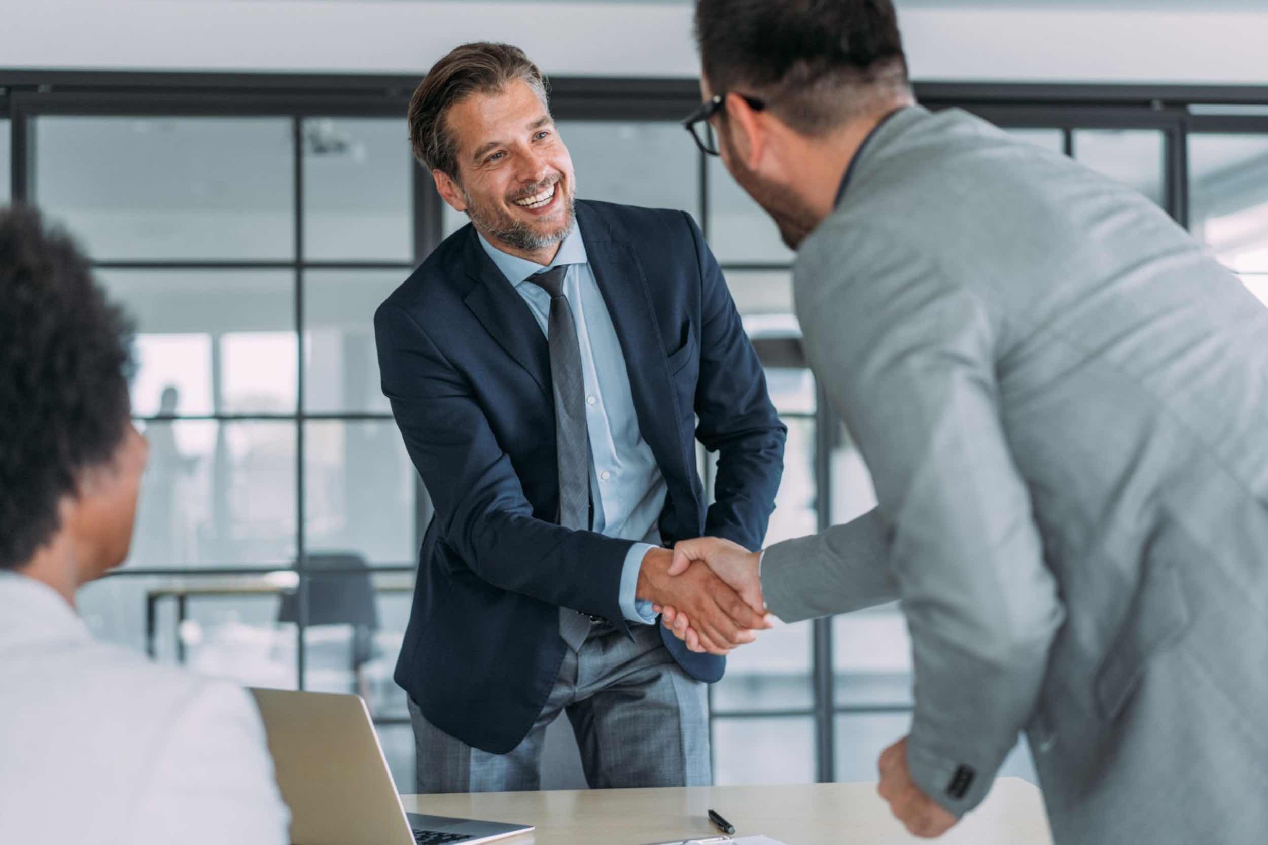 Business professionals shaking hands in a meeting, representing NANUK reseller partnerships