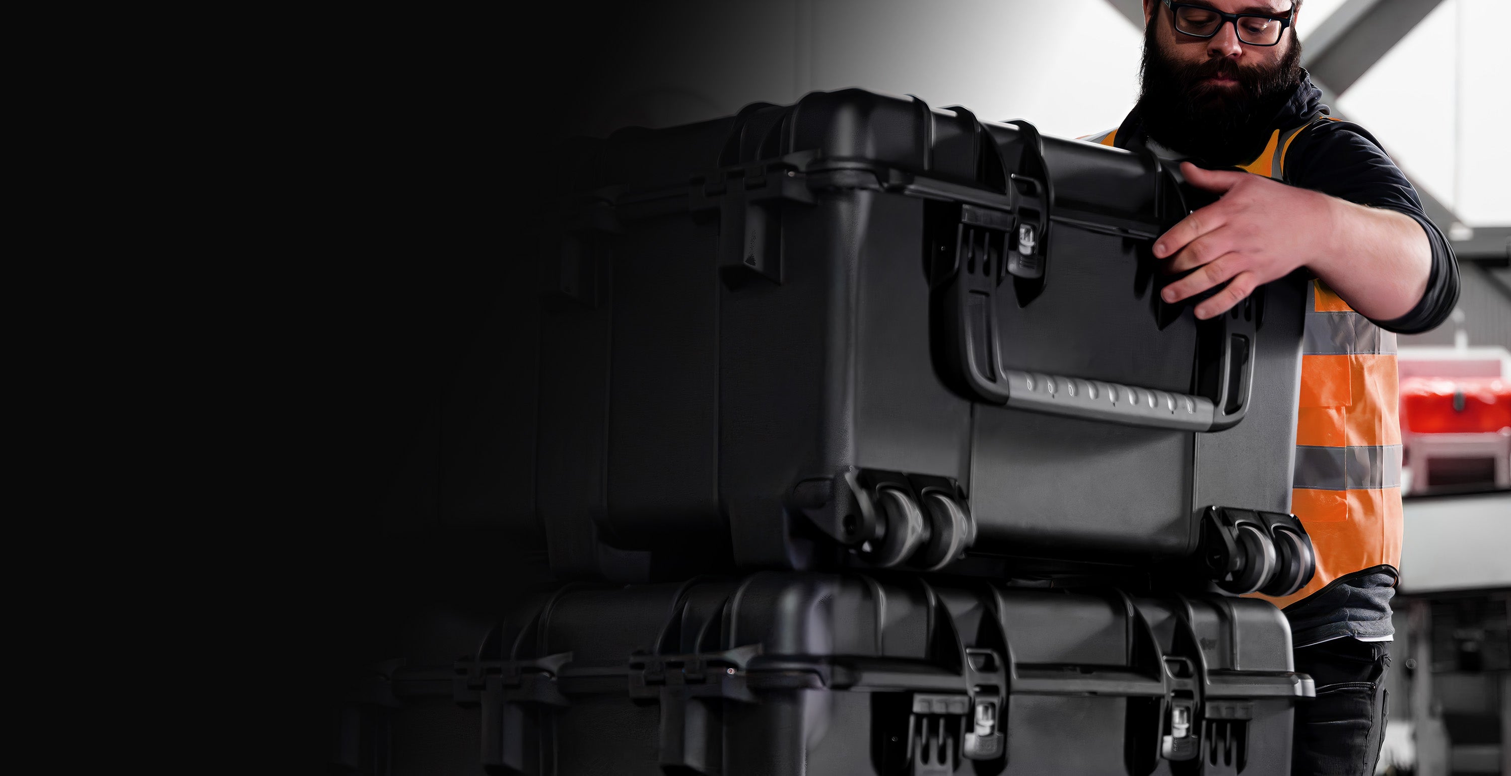 Worker in a warehouse stacking NANUK 976 Hard Cases on Wheels