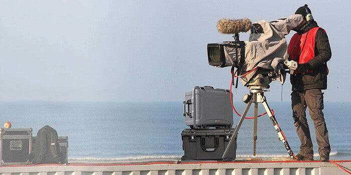 Camera Operator shooting a movie with Nanuk cases near the ocean