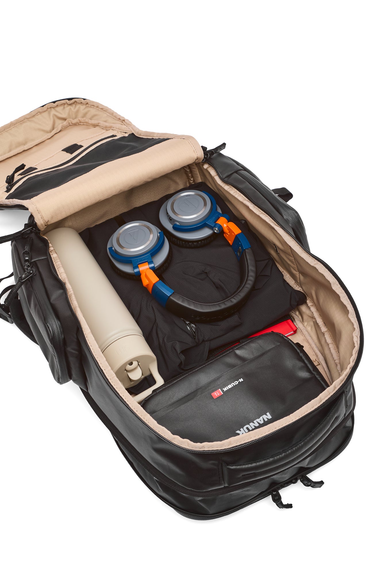 Open backpack with rolled-up mat and camping gear on a white background