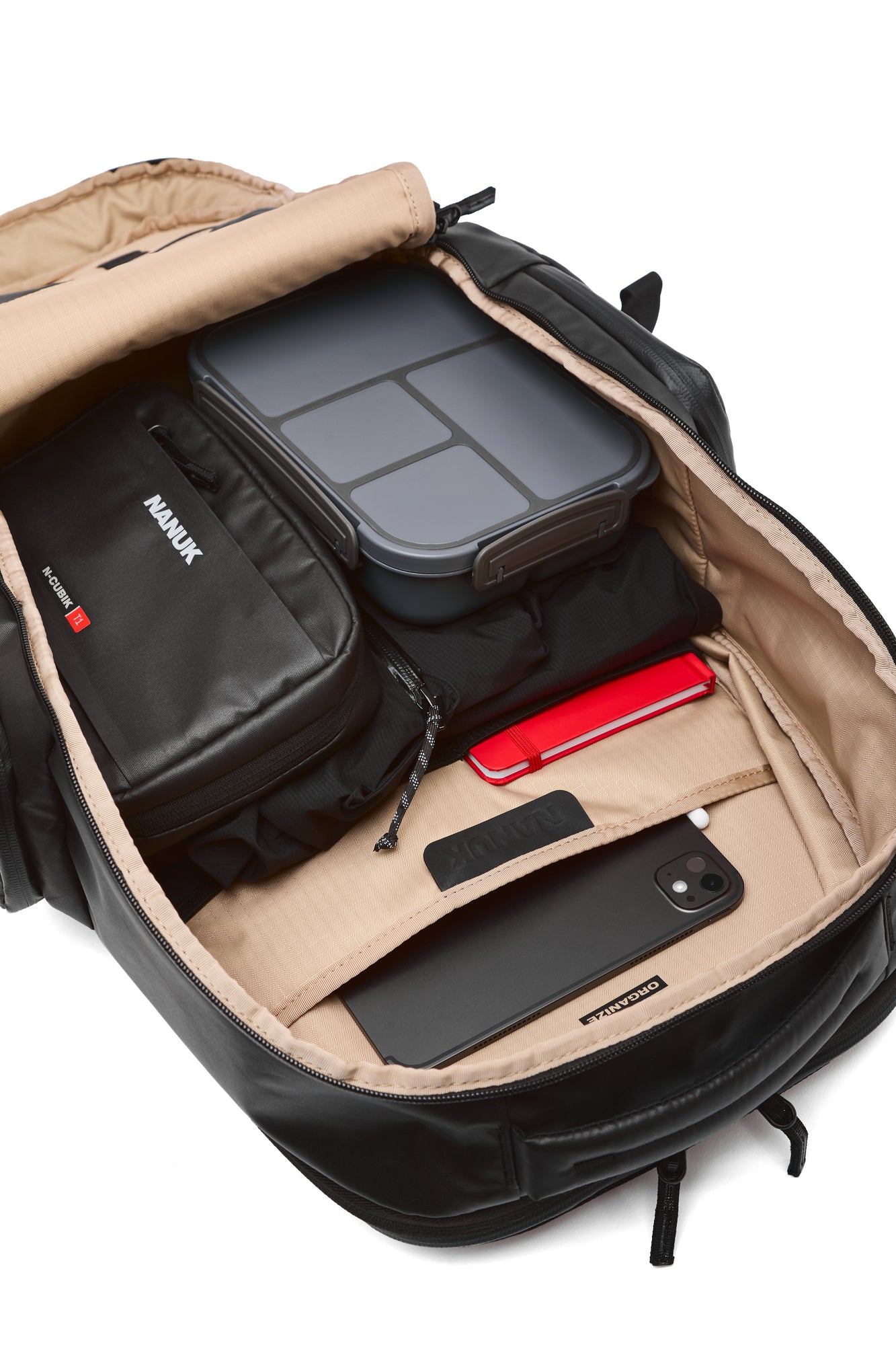 Open backpack with various items including a phone and a red object on a white background