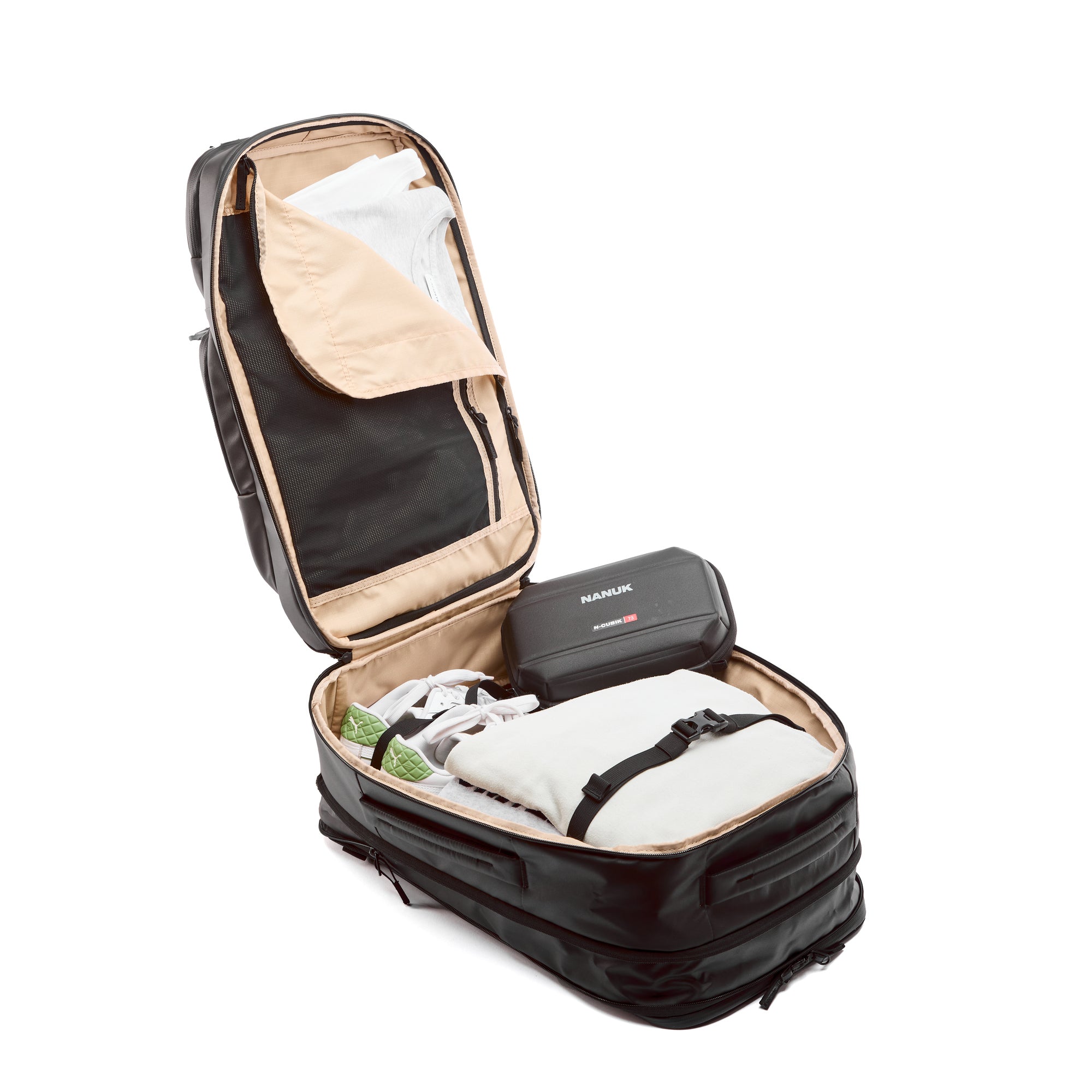 Black suitcase with beige interior, partially packed with clothes and a black device, on a white background.