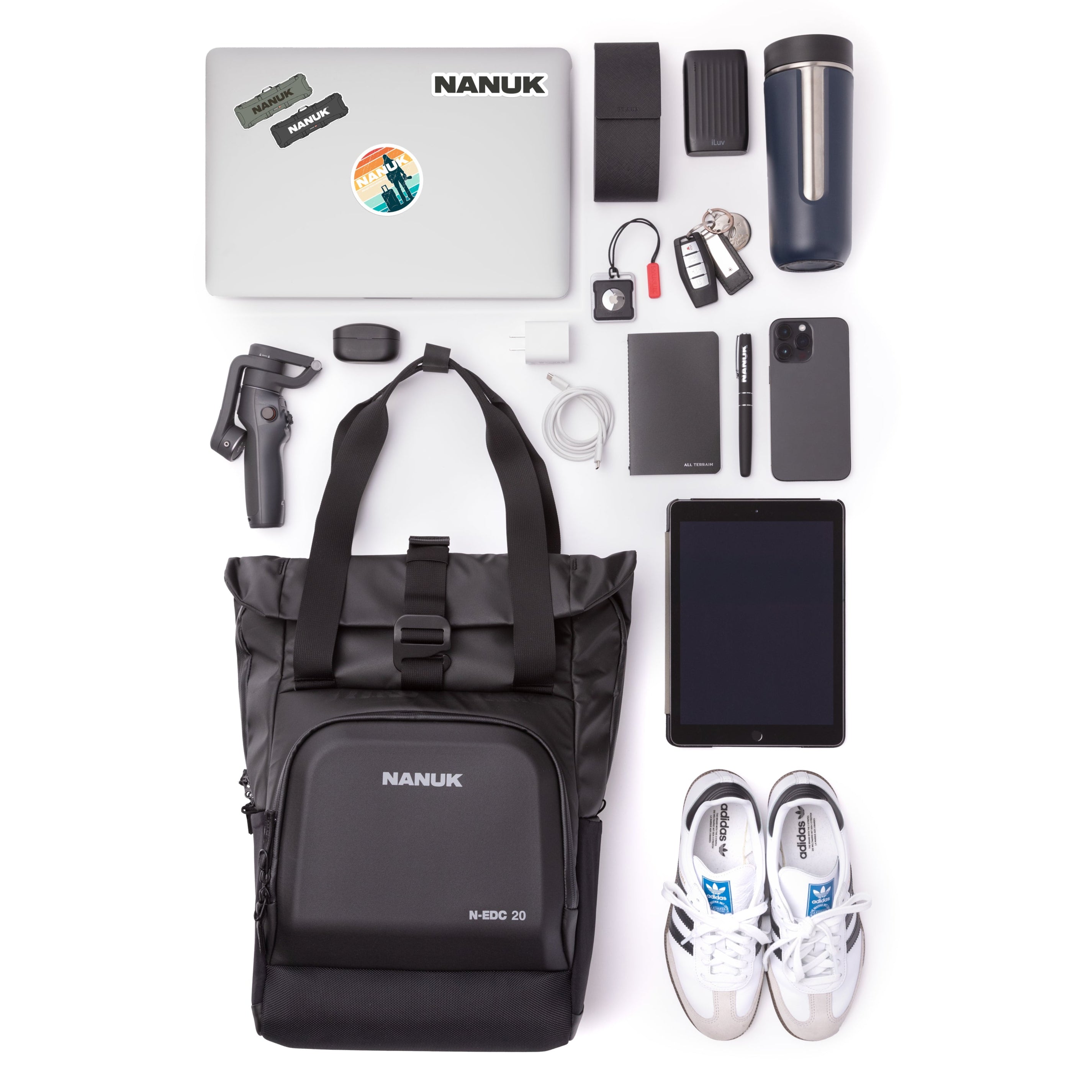 Collection of travel items including a laptop, backpack, shoes, and electronic devices on a white background.