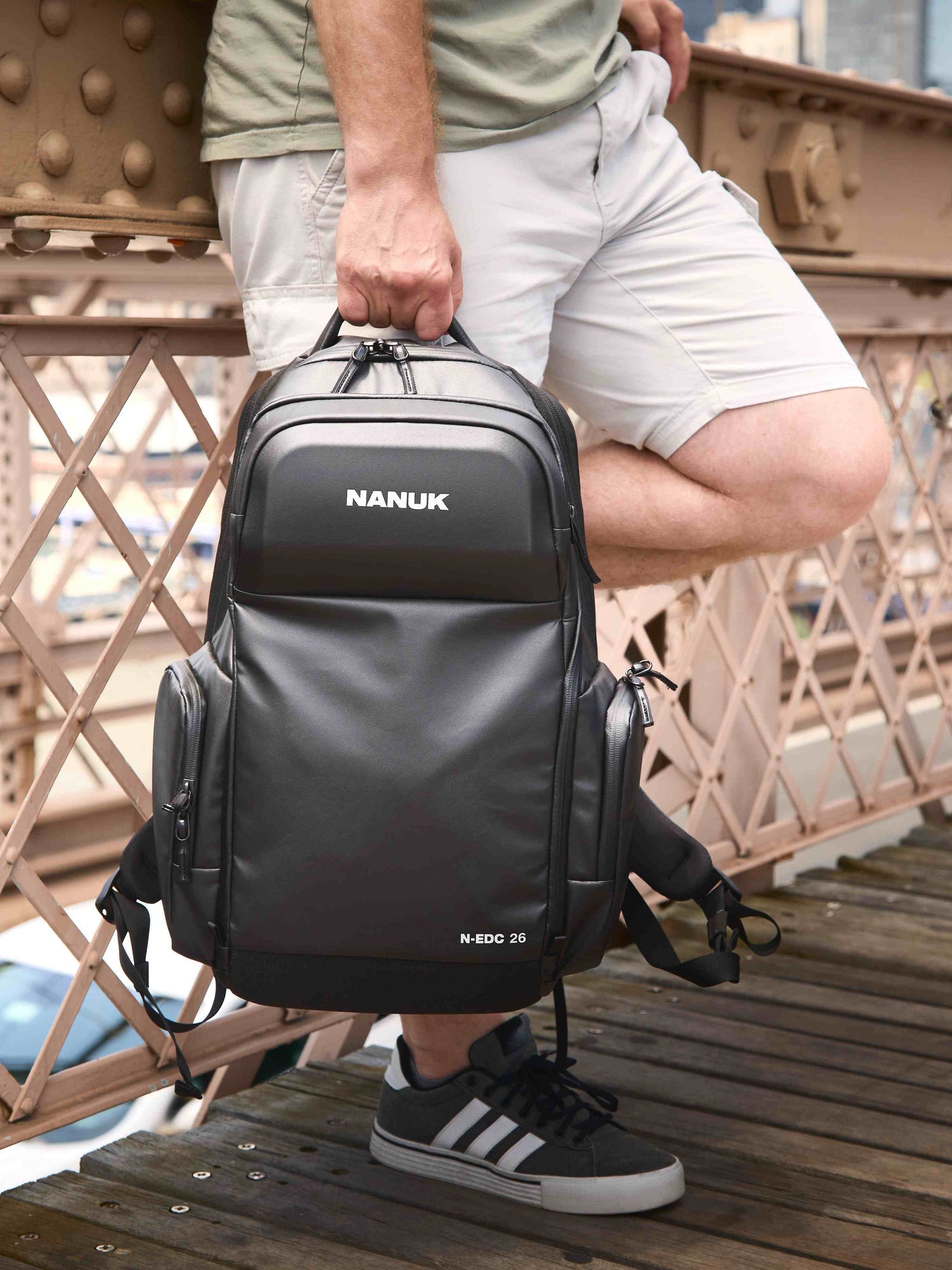 Person holding a NANUK backpack on a bridge