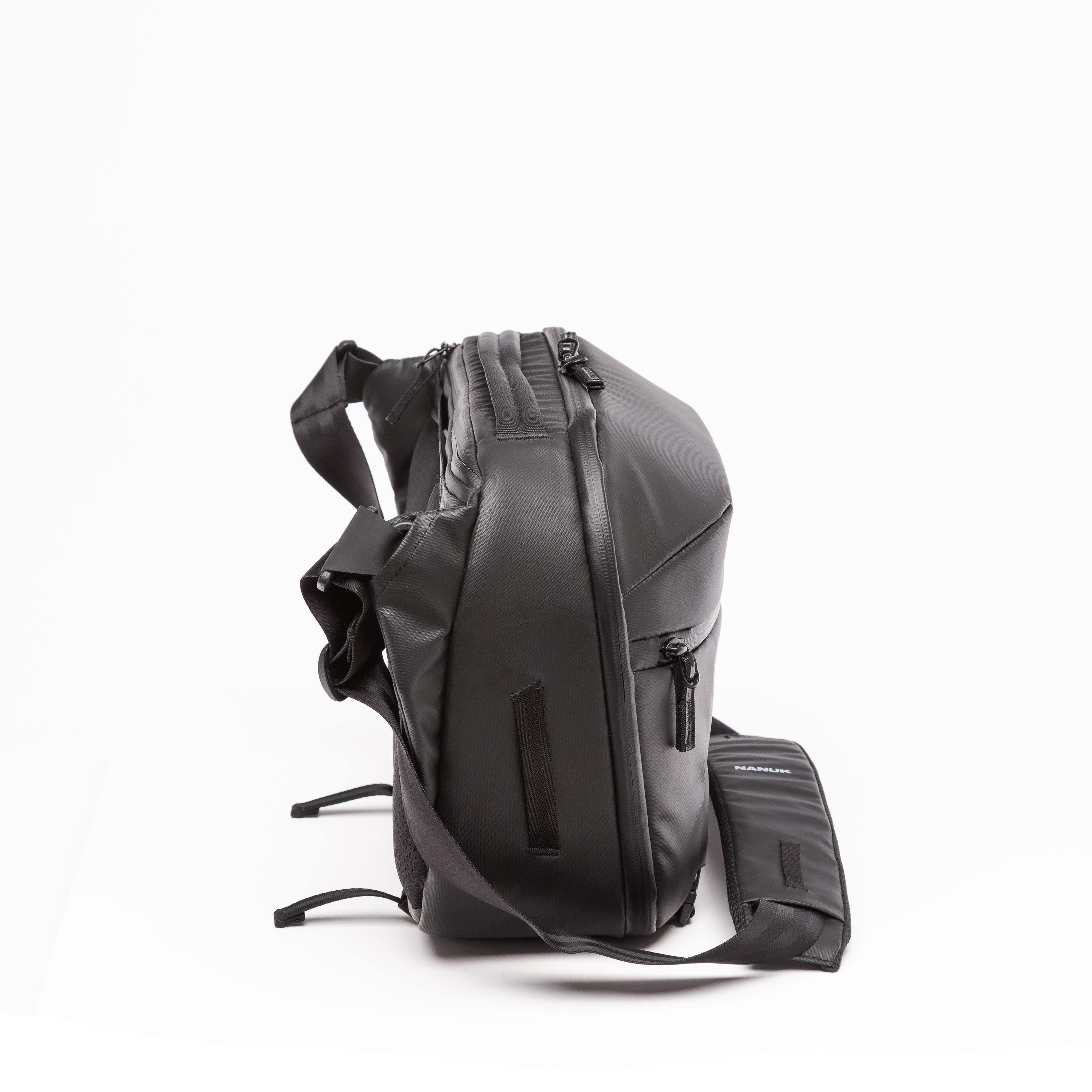 A black backpack with an attached matching pouch, shown from a side profile view on a clean white background.