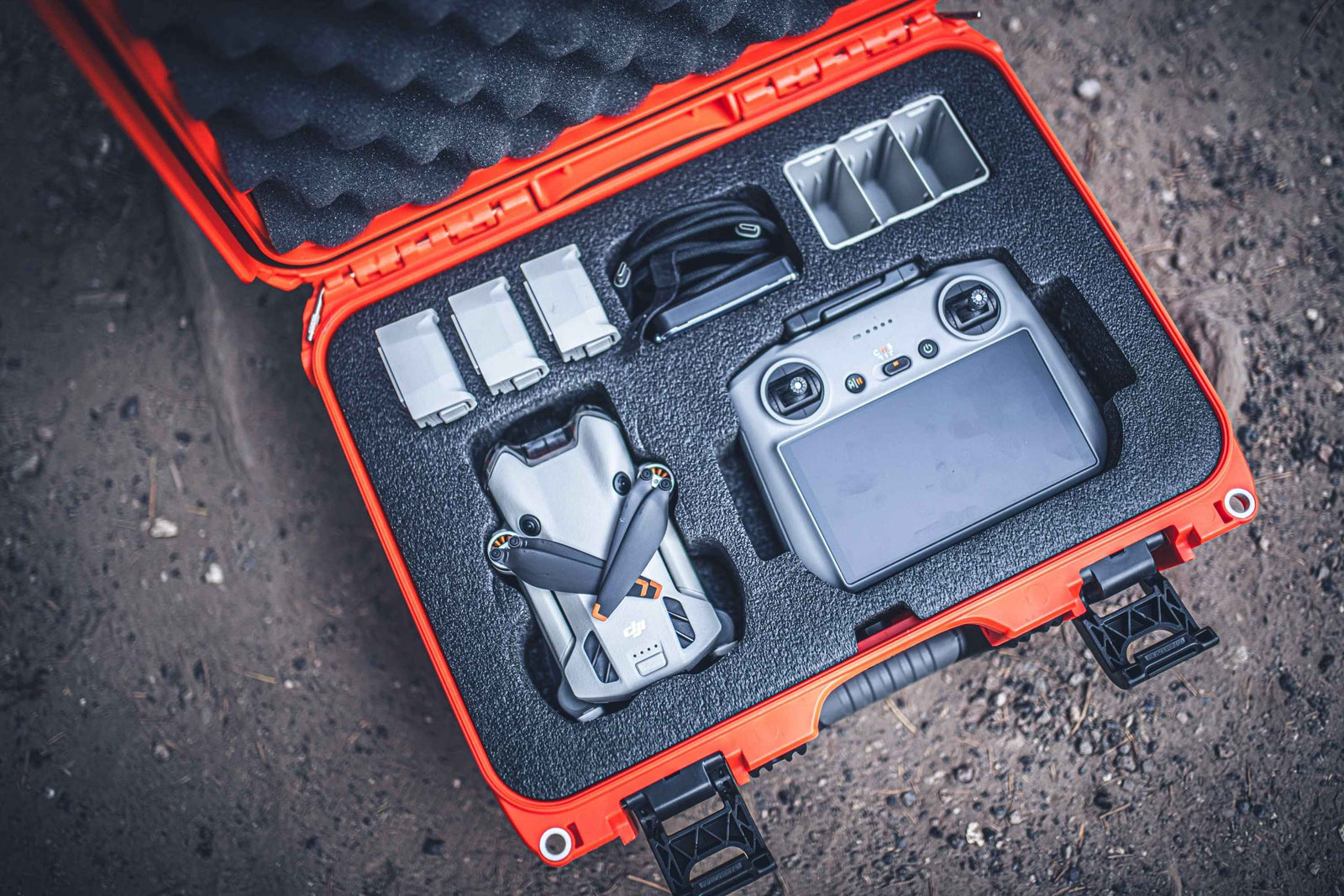 DJI Mavic Mini drone in an open red and black case on a dark textured surface