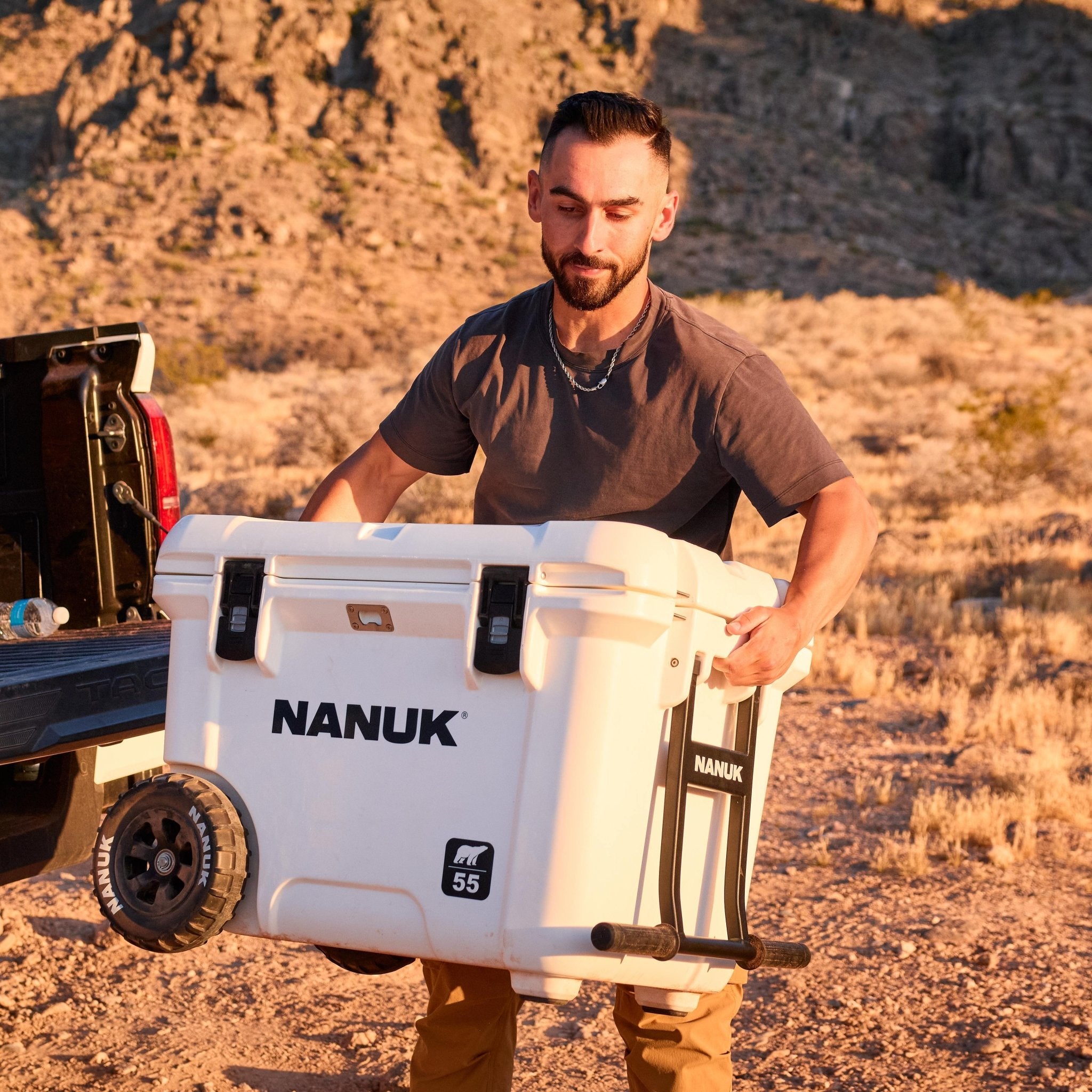 Man holding a NANUK cooler in a desert setting
