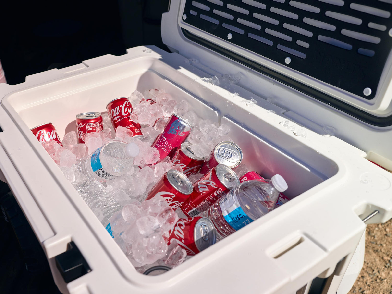 Cooler with Coca-Cola bottles and ice, outdoors