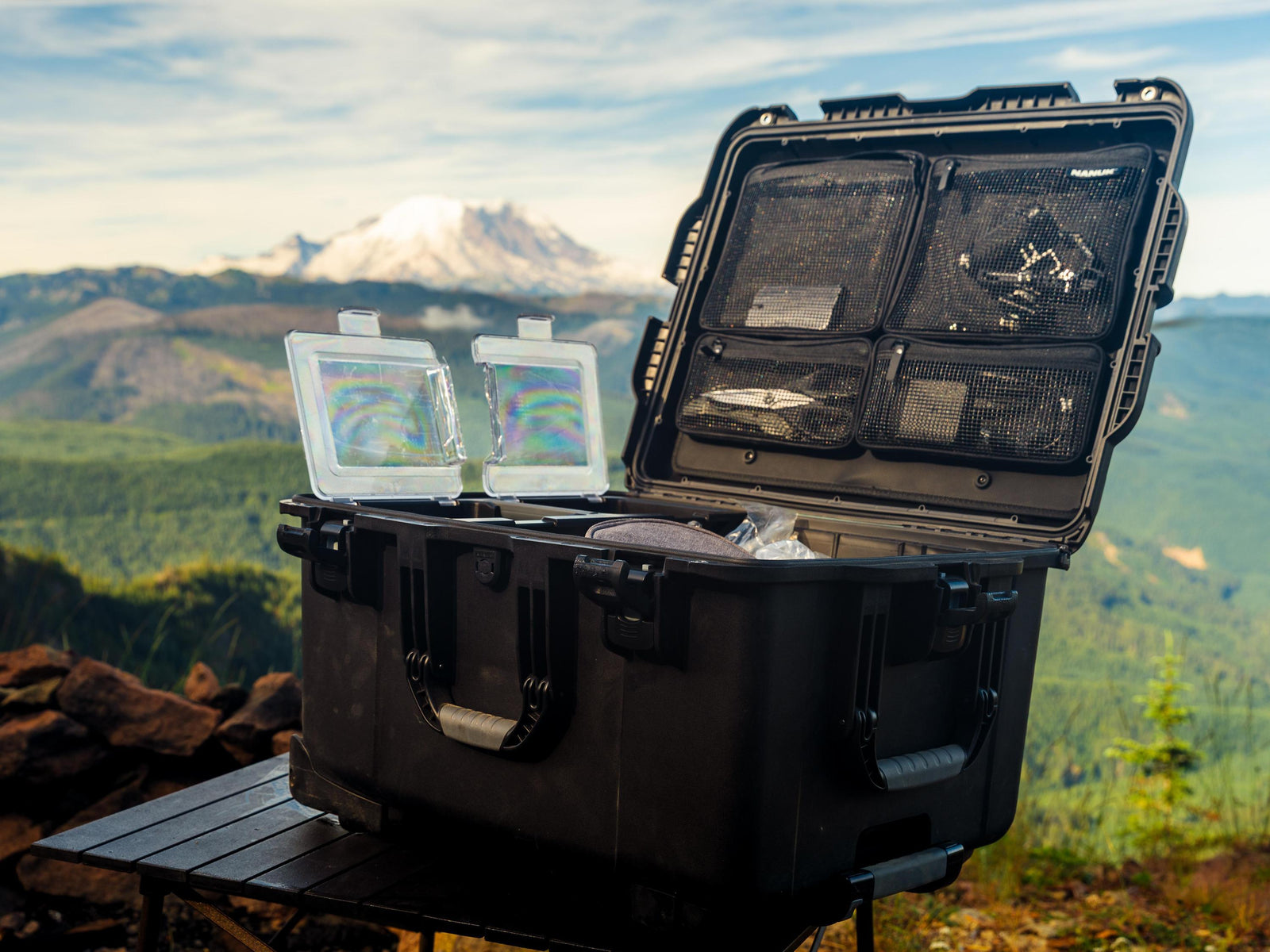 Black outdoor storage case with two screens on a mountain landscape
