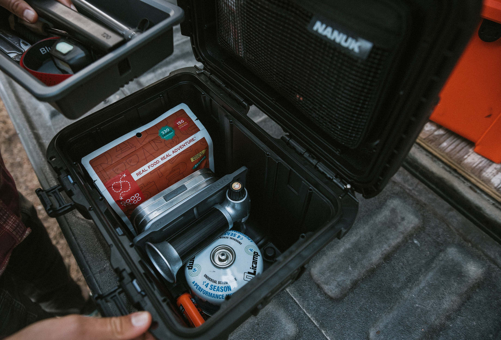NANUK Trail 10 hard case open in the back of a vehicle, revealing organized camera gear and accessories.