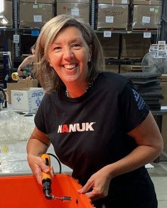 Person wearing a black Hanuk shirt in a warehouse setting